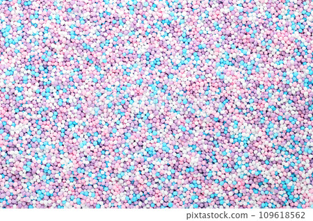 Colorful sprinkles made of tiny sugar balls. Mix of purple, blue, rose and white nonpareils. Decorative and edible Hundreds and Thousands made of sugar and starch, used as decoration and as topping. 109618562