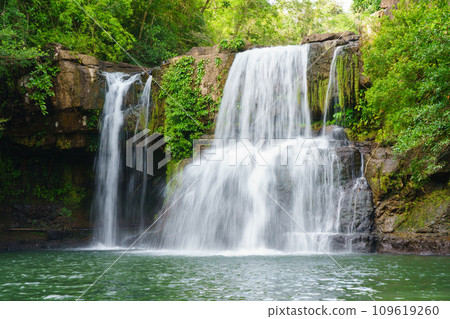 Klong Chao waterfall serenely cascades and green water below in Koh Kood island, Thailand. Klong Chao waterfall serenely cascades and green water below in Koh Kood island, Thailand. 109619260