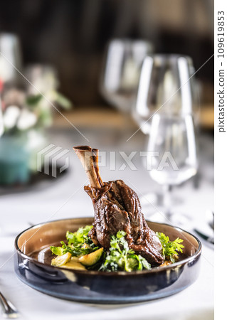Confit leg of lamb on mashed potatoes with creamy kale, demi glace sauce and herbs in the hotel restaurant 109619853