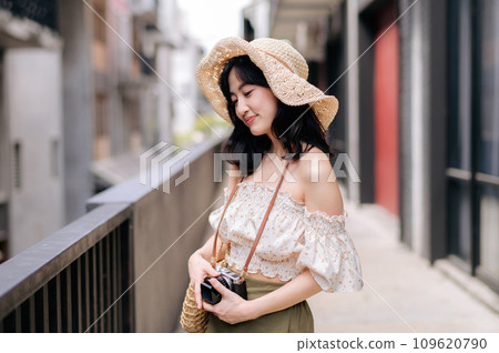 Happy youth asian woman with camera travels street city trip on leisure weekend. Young hipster female tourist sightseeing summer urban Bangkok destination. Asia summer tourism concept. 109620790