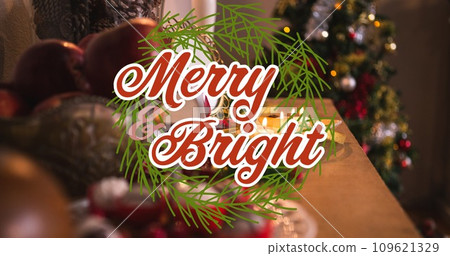 Composition of merry and bright text over christmas decorations on table 109621329