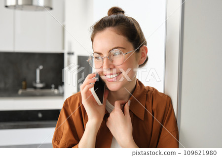 Portrait of happy smiling young woman at home, talking on mobile phone, calling friend and having nice conversation, answer telephone Portrait of happy smiling young woman at home, talking on mobile phone, calling friend and having nice conversation, answer telephone 109621980