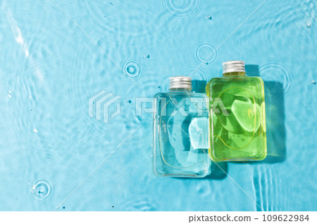 Beauty product bottles in water with copy space background on blue background 109622984