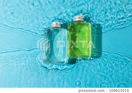 Beauty product bottles in water with copy space background on blue background 109623018