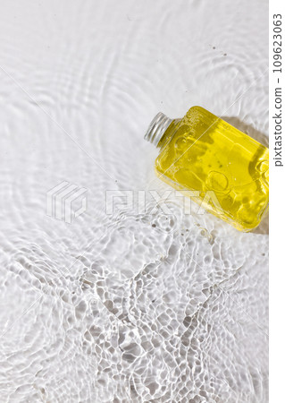 Vertical image of beauty product bottle in water with copy space background on white background 109623063