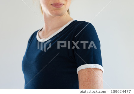 Mid section of caucasian woman in blue t-shirt with white trims and copy space on white background Mid section of caucasian woman in blue t-shirt with white trims and copy space on white background 109624477