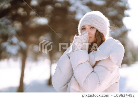 Happy woman in winter style clothes walking in the snowy park. Nature, holidays, travel concept. 109624492