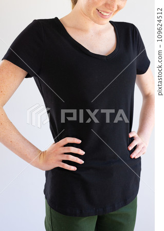 Vertical image of smiling caucasian woman in black t-shirt and copy space on white background Vertical image of smiling caucasian woman in black t-shirt and copy space on white background 109624512
