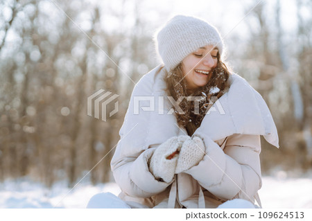 Happy woman in winter style clothes walking in the snowy park. Nature, holidays, travel concept. Happy woman in winter style clothes walking in the snowy park. Nature, holidays, travel concept. 109624513
