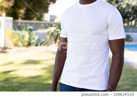 Mid section of african american man in white t-shirt with copy space in garden Mid section of african american man in white t-shirt with copy space in garden 109624520