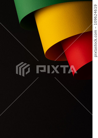 Vertical image of green, yellow and red papers with copy space on black background Vertical image of green, yellow and red papers with copy space on black background 109624619