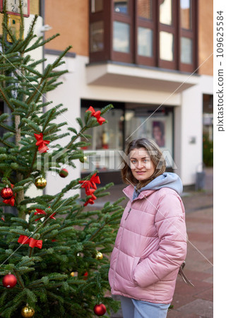 A beautiful girl stands on the street of the old European town of Bietigheim-Bissingen in Germany on Christmas Eve. Christmas Magic in Bietigheim-Bissingen Streets. City streets are decorated with A beautiful girl stands on the street of the old European town of Bietigheim-Bissingen in Germany on Christmas Eve. Christmas Magic in Bietigheim-Bissingen Streets. City streets are decorated with 109625584