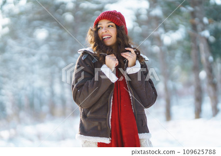 Happy woman standing among snowy trees and enjoying first snow. Holidays, rest, travel concept Happy woman standing among snowy trees and enjoying first snow. Holidays, rest, travel concept 109625788
