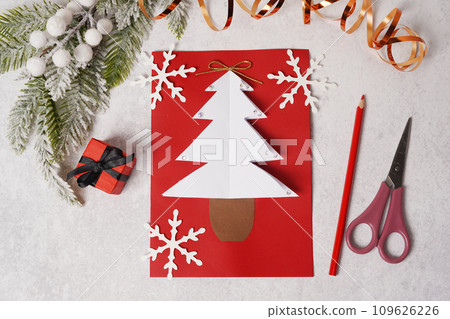 Handmade Christmas greeting card with Christmas tree from paper. Children's DIY concept Handmade Christmas greeting card with Christmas tree from paper. Children's DIY concept 109626226