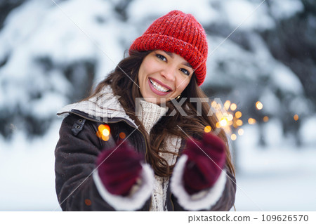 Stylish woman with bengal light in hand enjoying and have fan winter holidays among snowy landscape. 109626570