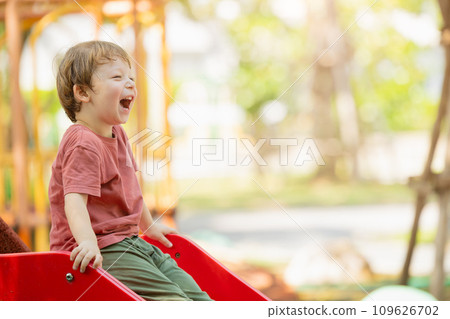 happy playful boy fun laugh smiling kid enjoy playing activity at the playground outdoor park summer. 109626702