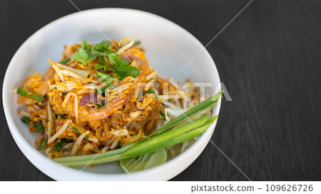 Pad thai coriander on top juicy creamy tasty delicious world popular. Thai famous food menu closeup in bowl on black wood table. 109626726