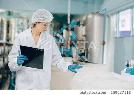 science worker work in water treatment plant checking quality and cleanliness purity of water in container tank. science worker work in water treatment plant checking quality and cleanliness purity of water in container tank. 109627118