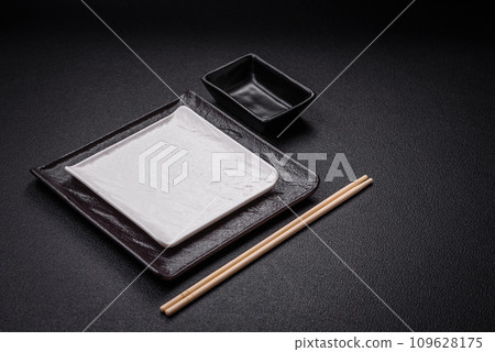 Square empty ceramic plate on textured concrete background Square empty ceramic plate on textured concrete background 109628175