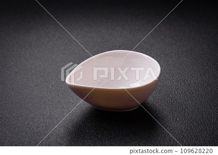Beautiful empty white ceramic gravy boat on a textured concrete background 109628220