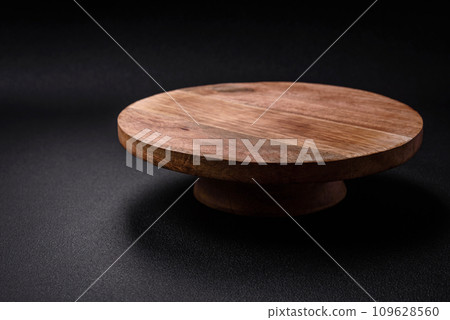 Beautiful round wooden cake stand on a textured concrete background 109628560