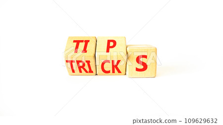 Tips and tricks symbol. Turned wooden cubes and changed the word tricks to tips. Beautiful white table, white background. Business, tips and tricks concept. Copy space. 109629632
