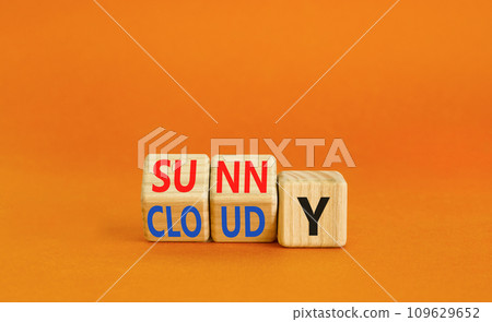 Sunny or cloudy symbol. Concept word Sunny or Cloudy on wooden cubes. Beautiful orange table orange background. Business lifestyle and sunny or cloudy concept. Copy space. 109629652