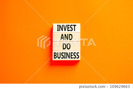 Invest and do business symbol. Concept word Invest and do business on beautiful wooden block. Beautiful orange table orange background. Invest and do business concept. Copy space. Invest and do business symbol. Concept word Invest and do business on beautiful wooden block. Beautiful orange table orange background. Invest and do business concept. Copy space. 109629663