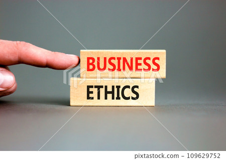 Business ethics symbol. Concept words Business ethics on beautiful wooden blocks. Beautiful grey table grey background. Businessman hand. Business ethics concept. Copy space. 109629752