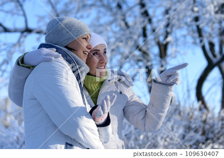 Happy women in winter clothes posing outdoors 109630407