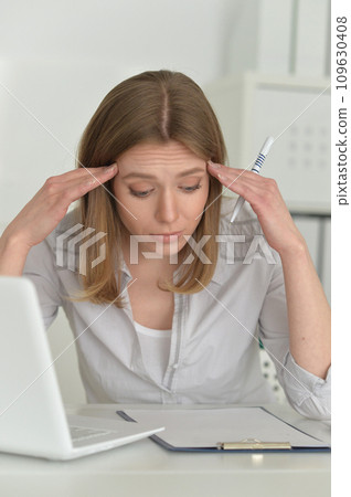 Young sad business woman working in office with laptop 109630408