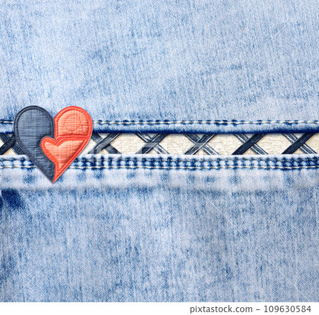 Light blue denim background with a seam and felt heart. Suqare blue color denim jeans fabric texture with heart-shaped textile patch. Valentine's day denim backdrop. Copy space for text 109630584