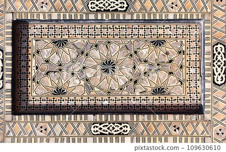 Detail of ancient mosaic window shutter with mother-of-pearl ornaments. Horizontal or vertical background with traditional moroccan tile decoration 109630610