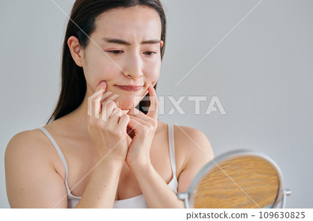 30多歲的女性在照鏡子時擔心自己皮膚上有皺紋 109630825