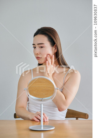 30多歲的女性在照鏡子時擔心自己皮膚上有皺紋 30多歲的女性在照鏡子時擔心自己皮膚上有皺紋 109630837