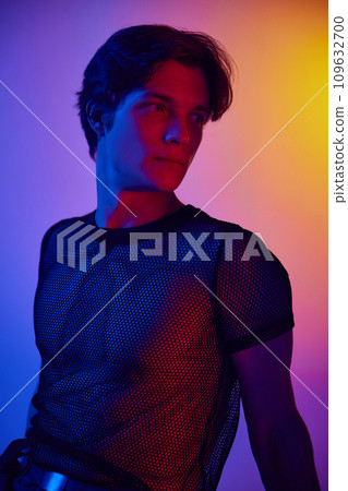 Portrait of handsome young man in stylish clothes posing over multicolored background in neon lights. 109632700