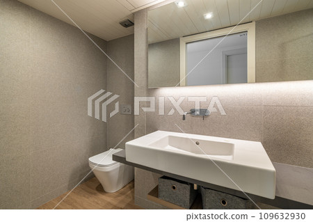Hanging ceramic sink with tap and large mirror in bathroom 109632930