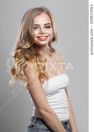 Joyful lady with curly hairdo standing on white background. Beauty woman portrait 109633063