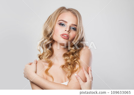 Nice female face. Blonde woman with long curly hair and makeup studio portrait 109633065