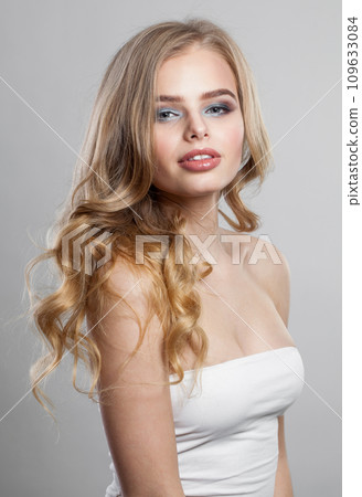 Cheerful female model woman. Fresh skin, trendy makeup and wavy blonde hair Cheerful female model woman. Fresh skin, trendy makeup and wavy blonde hair 109633084