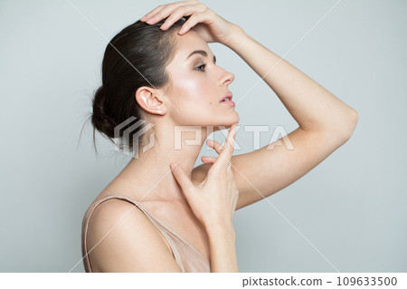 Glamorous woman touching her flawless glowy fresh clean facial skin, portrait. Healthcare, wellness Glamorous woman touching her flawless glowy fresh clean facial skin, portrait. Healthcare, wellness 109633500