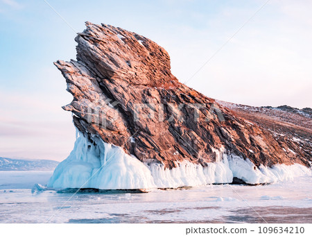 Ogoy island on winter Baikal lake. Winter scenery of Dragon Tail Rock on Ogoy island during sunrise at Lake Baikal. Ogoy island on winter Baikal lake. Winter scenery of Dragon Tail Rock on Ogoy island during sunrise at Lake Baikal. 109634210