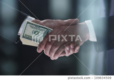 Handshake with the transfer of money on a black background 109634509