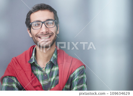 Smiling handsome man in shirt standing with crossed arms on gray background 109634629