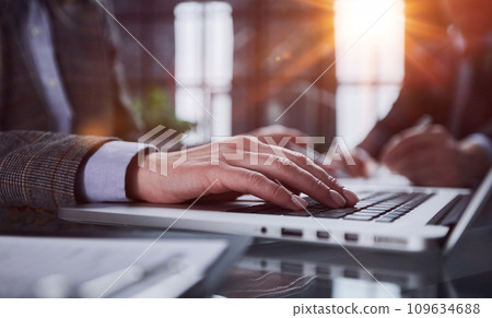 man's hands typing on laptop keyboard in interior man's hands typing on laptop keyboard in interior 109634688