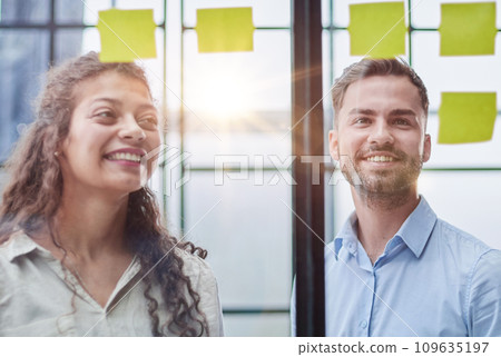 Business people talking in the hallway of the modern office building with employees working behind glass partitions. Work in a large business corporation 109635197