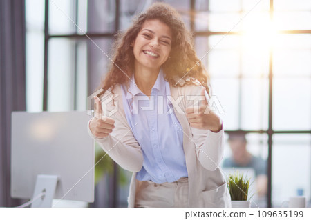 Proud office worker posing with thumbs up Proud office worker posing with thumbs up 109635199