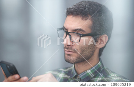 positive young male holding smartphone, chatting in social network with friends 109635219