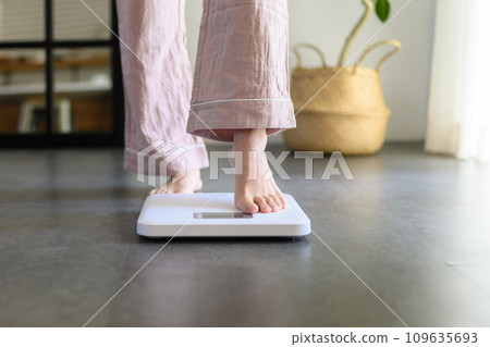 A woman in her 20s weighing herself A woman in her 20s weighing herself 109635693