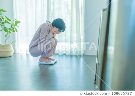 A woman in her 20s weighing herself A woman in her 20s weighing herself 109635727